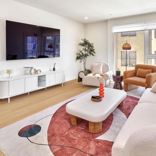 a living room with a white couch and a red rug