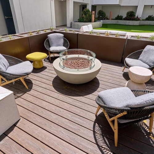a patio with chairs and a fire pit